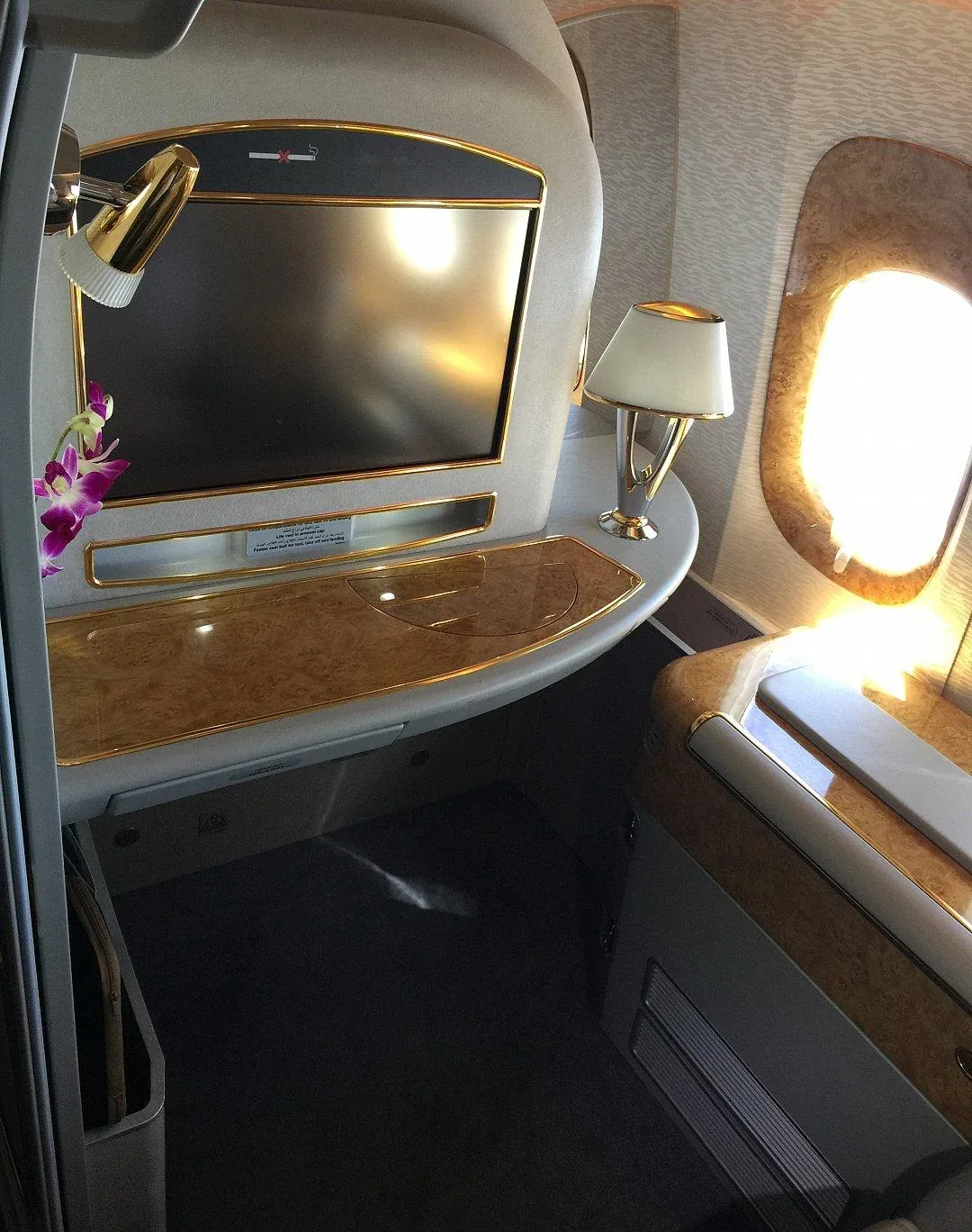 Кабина первого класса 777-300ER Emirates с накрытым столом на три иллюминатора