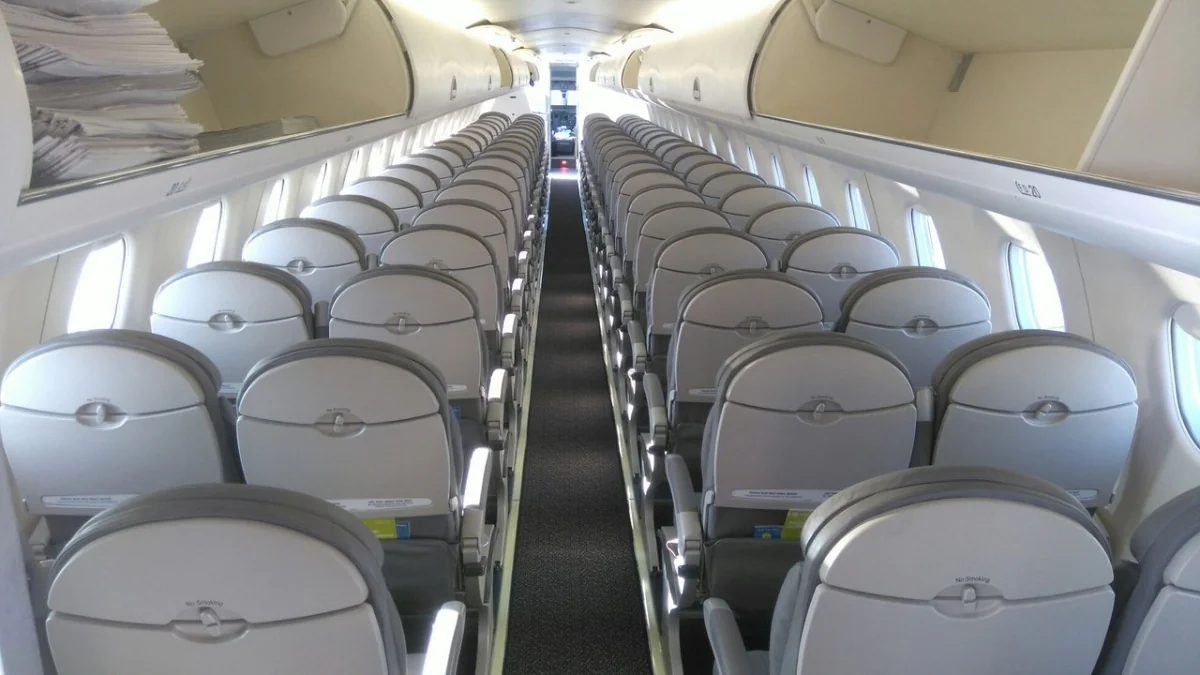 Embraer 170 S7: серые кресла уходят к хвосту, узкий проход между парами